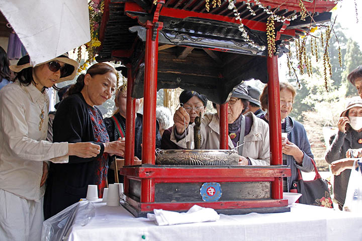 釈迦の像に甘茶をかける参拝客