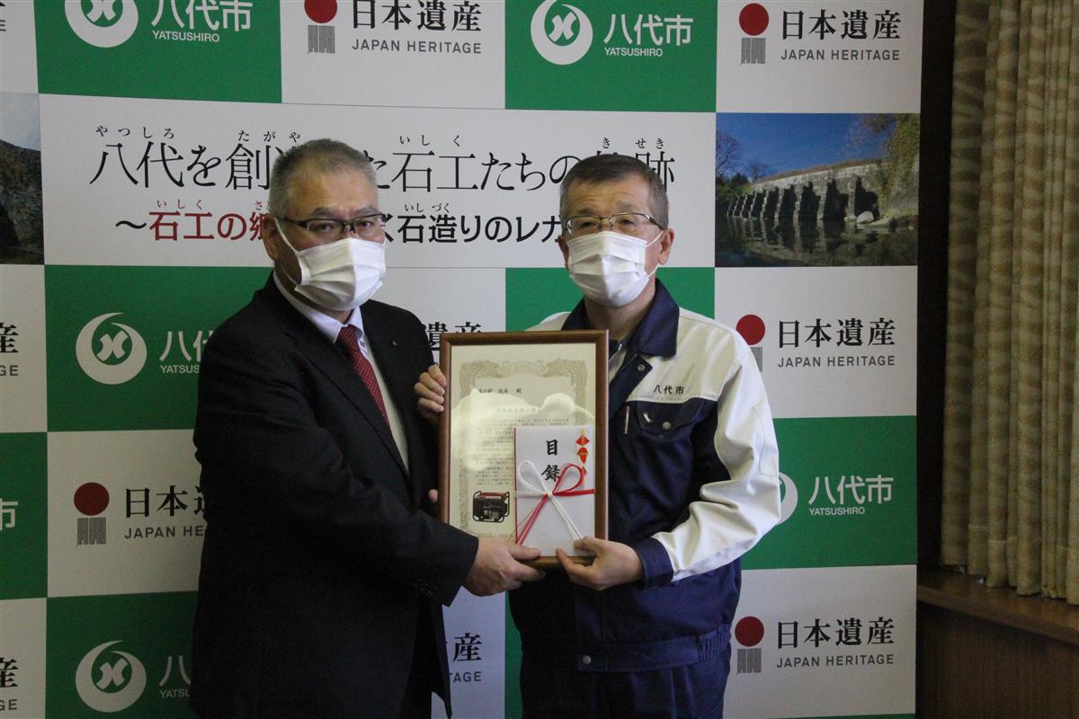 目録を手渡す日本道路建設業協会九州支部の森田支部長（左）
