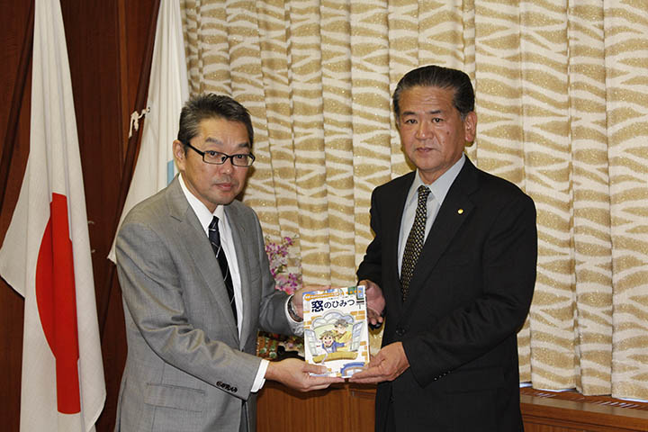 小学生向け学習教材を寄贈したYKKAP九州製造所の阿部浩司所長（左）