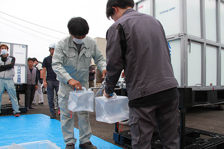 専用蛇口を取り付け給水袋に給水する組合員