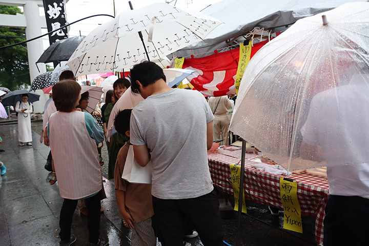 雨の中雪持ちの行列に並ぶ参拝客ら