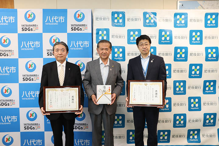 左から和久田代表取締役、中村市長、中野八代ブロック統括店長