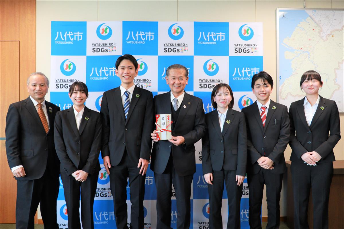 イ草で作られた目録を手に記念撮影の画像