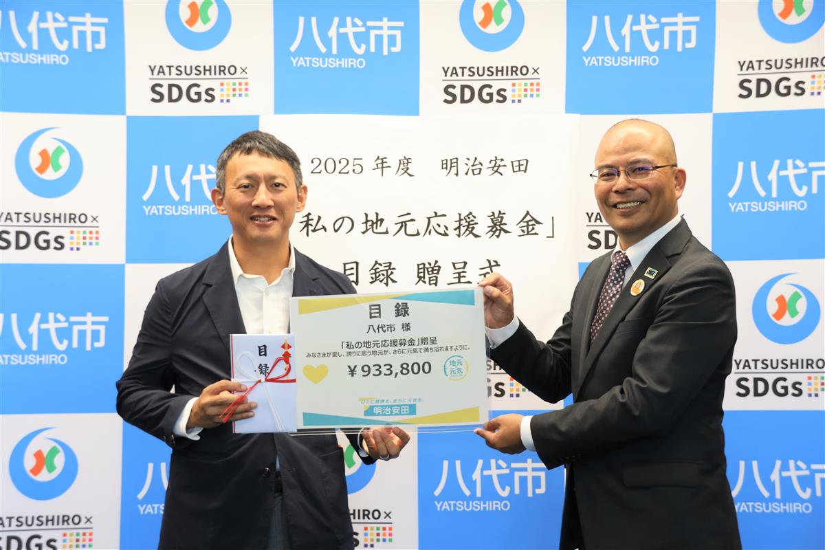 寄付金額が入ったパネルと目録を手にする小野市長（左）と樽木聡八代営業部長（右）の画像