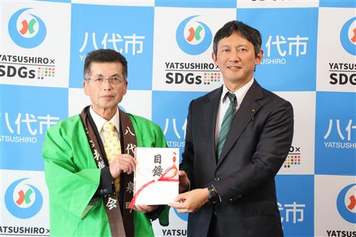 目録を手にする松田会長(左)と小野市長(右)