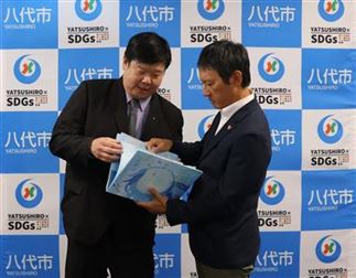 贈呈された絵本について意見交換する 小野市長（右）と王翔郁新竹市文化局長（左）
