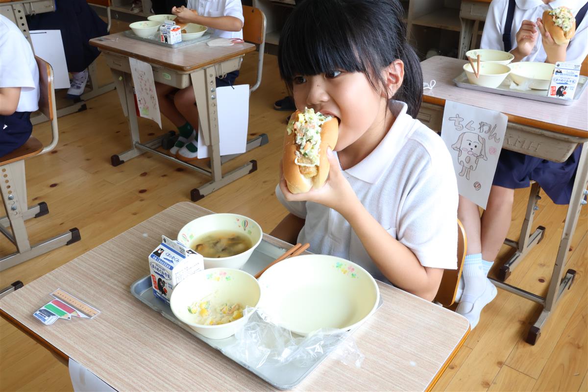 「ちくワンドッグ」をおいしそうに食べる児童の画像