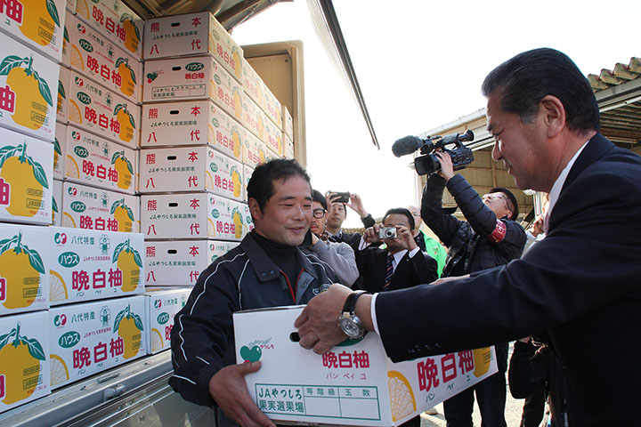 晩白柚を輸送トラックに積み込む中村博生市長（右）